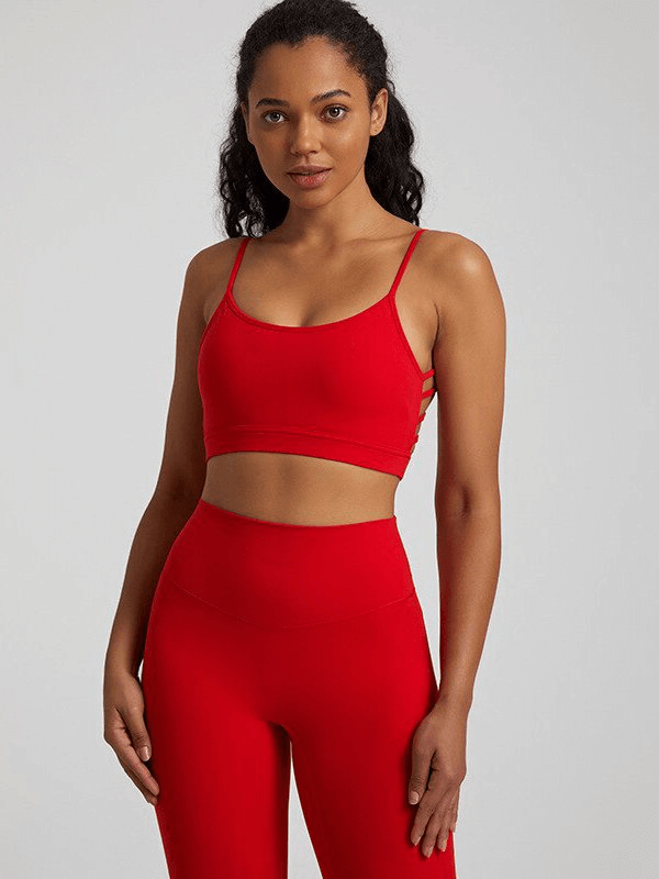 Red open-back sports bra for women, featuring solid color, nylon-spandex blend, ideal for workouts and activewear. Model shown wearing bra.