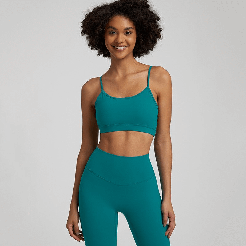 Woman modeling teal solid color open back sports bra, perfect activewear for workouts, featuring quick-dry fabric and comfortable fit, SF1488.