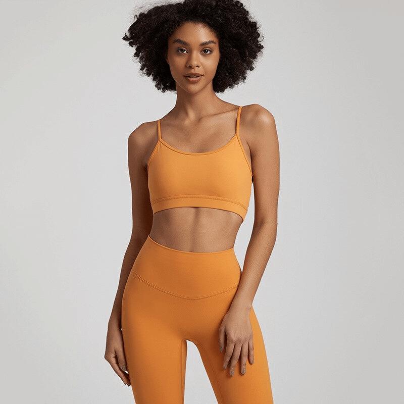 Alt Tag: Female solid color open back sports bra in orange, perfect for activewear. Features stretchy, quick-dry fabric for workouts.