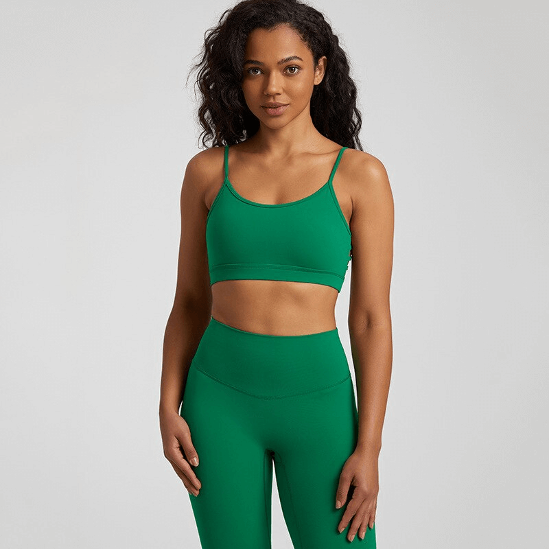 Woman wearing green solid color open back sports bra for activewear, designed for breathability and comfort during workouts.