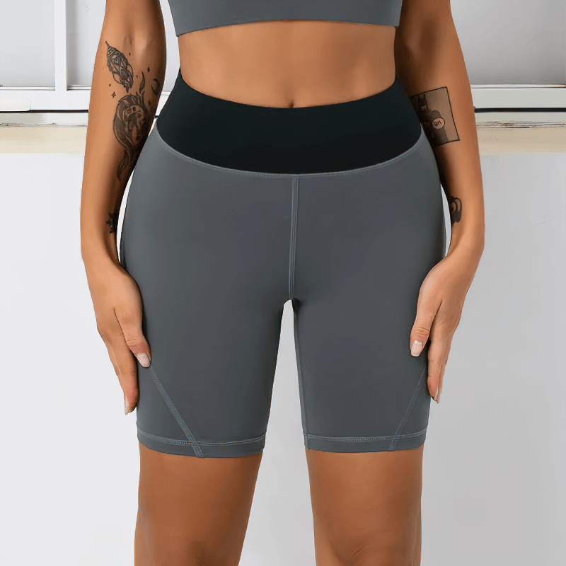 Woman wearing high waist two-color sports shorts, designed for comfort with quick-dry spandex and nylon, perfect for workouts.