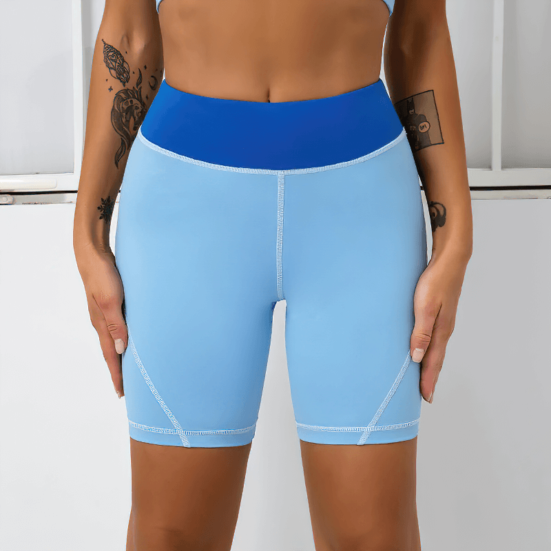 Woman wearing high waist two-color sports shorts in blue, perfect for workouts with quick-dry technology and superior comfort.