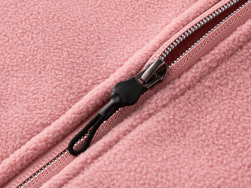 Close-up of pink fleece jacket zipper showing texture and craftsmanship.
