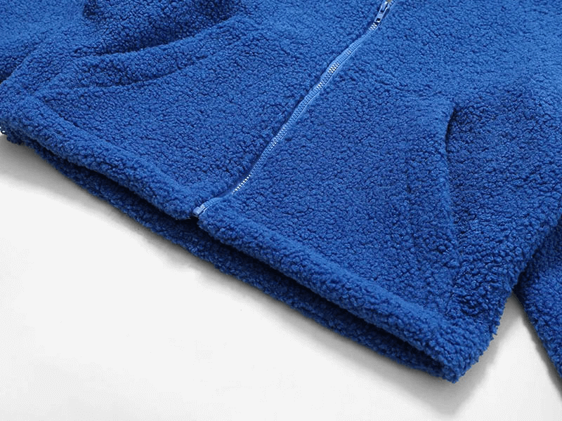 Close-up of blue thick fleece jacket with zipper, featuring breathable polyester material for warmth and comfort in winter.