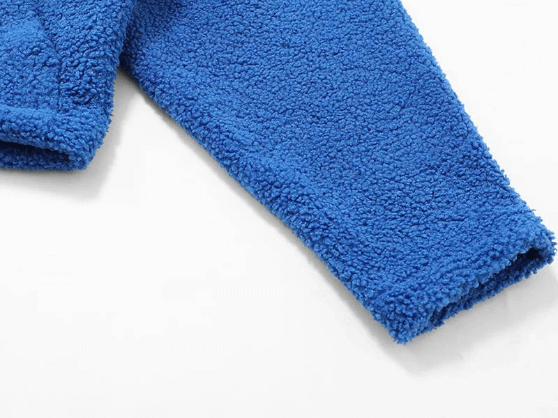 Close-up of blue fleece jacket sleeve showcasing thick, breathable polyester fabric and classic look for winter.