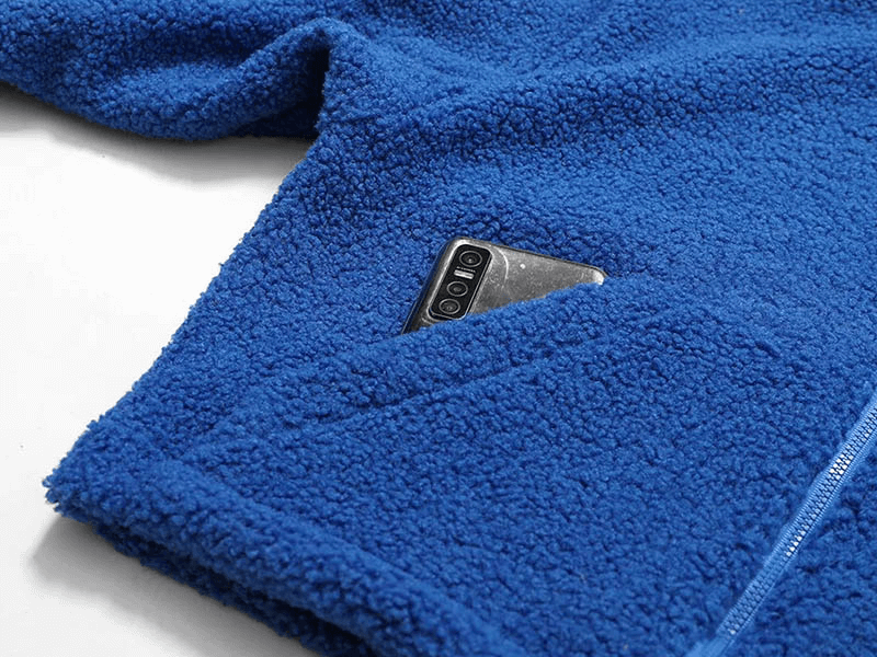 Blue fleece jacket with zipper displaying phone in pocket, showcasing warmth and functionality.