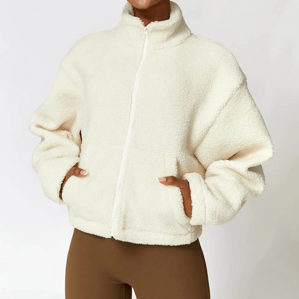 Woman wearing a warm, thick fleece jacket with zipper, ideal for winter. Made of polyester, solid color, perfect for a classic outfit.