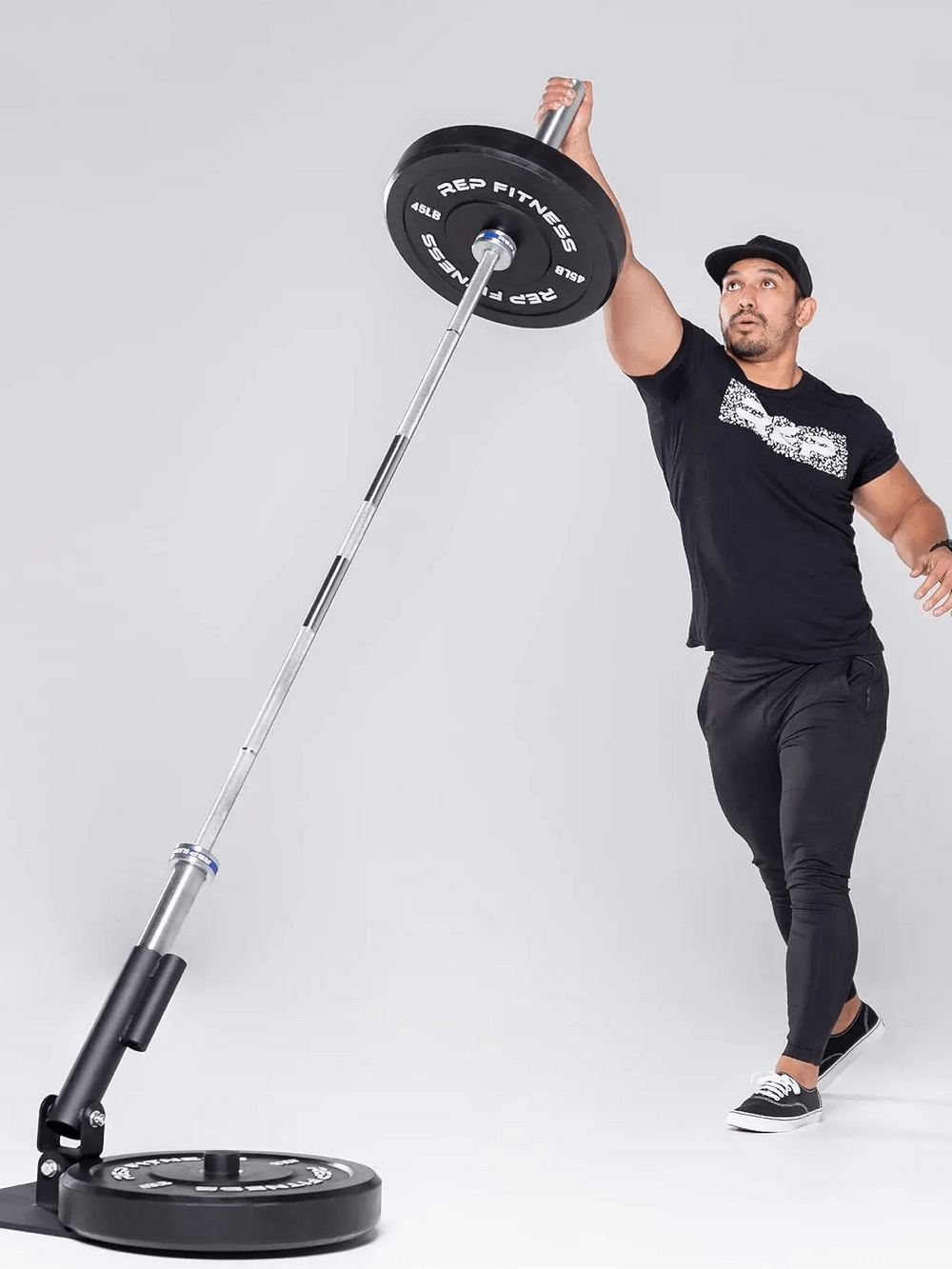 Man lifting barbell with REP Fitness bumper plates SF3337, showcasing strength training and conditioning capabilities.