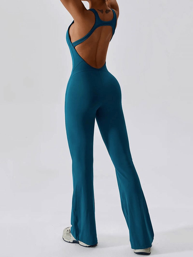 Woman wearing a blue open back compressed fitness jumpsuit for yoga and gym.
