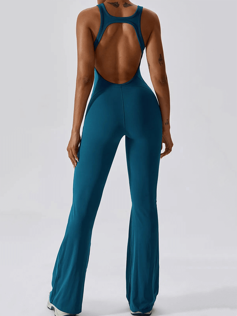 Woman wearing blue open back fitness jumpsuit for yoga and gym.