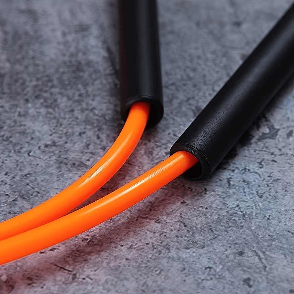 Close-up of durable orange PVC skipping rope for cardio and training, perfect for enhancing fitness routines.