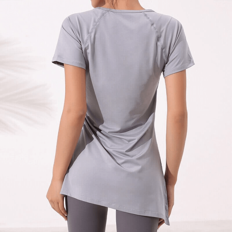 Woman wearing gray fitness long t-shirt with side drawstring, perfect for yoga. Anti-wrinkle, quick-dry polyester material.