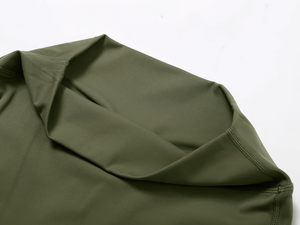 Close-up of olive green yoga pants fabric, highlighting soft, breathable material ideal for flexibility and comfort during workouts.