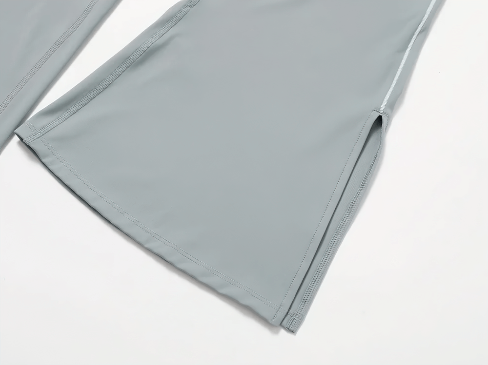 Close-up of flared high-waist bell-bottom yoga pants with side slits in gray, highlighting stylish design for fitness and yoga.