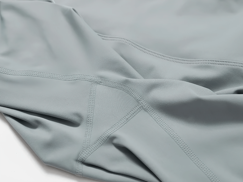 Close-up of high-waist flared yoga pants in grey, showing stitching detail. Ideal for gym, yoga, and running with a breathable fit.