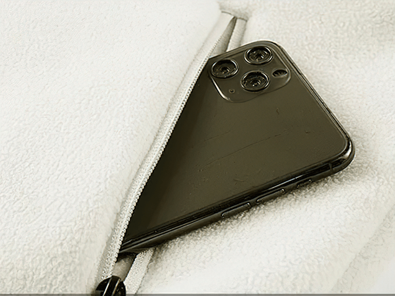 Smartphone peeking out from the pocket of a fleece zip-up jacket for men, showing the convenient pocket feature. SF1934 model.
