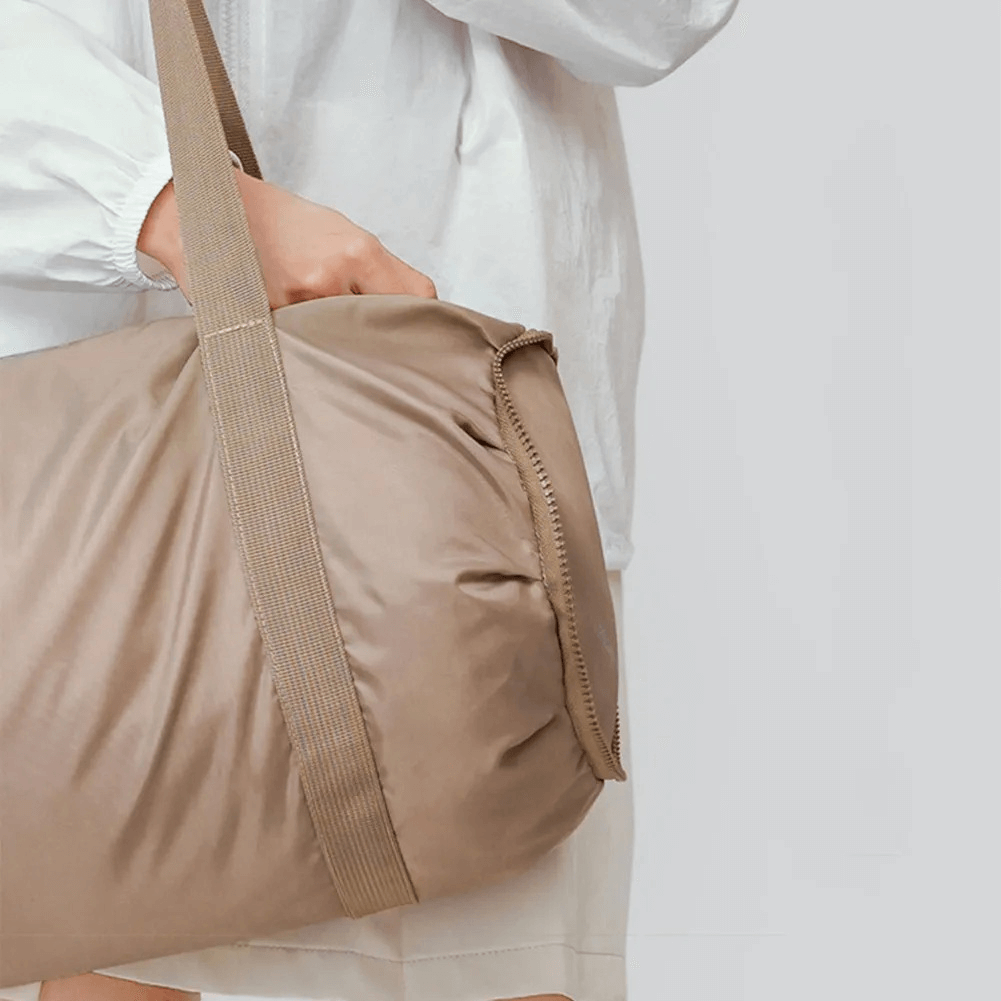 Person carrying a foldable lightweight training duffel bag made from durable polyester, ideal for sports and active lifestyles.