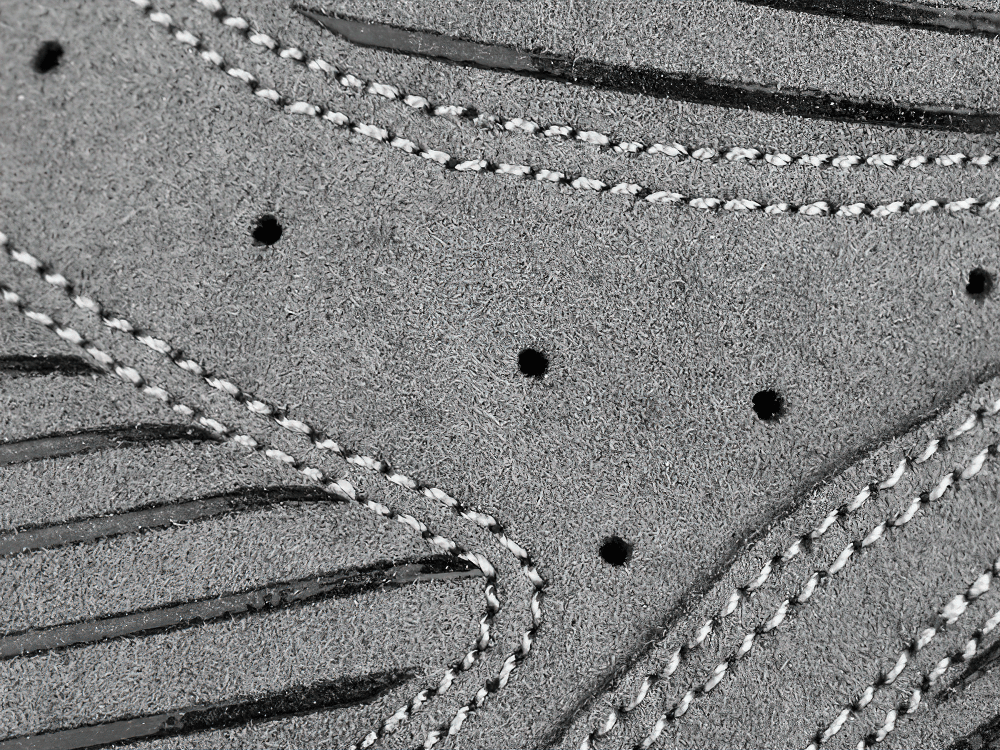 Close-up of breathable cycling glove fabric with stitching and air holes for ventilation and comfort during biking.