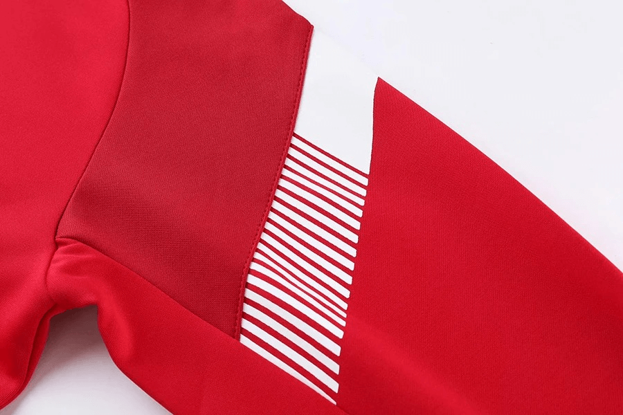 Close-up of red cycling jersey sleeve with reflective stripes for enhanced visibility, featuring durable polyester material.