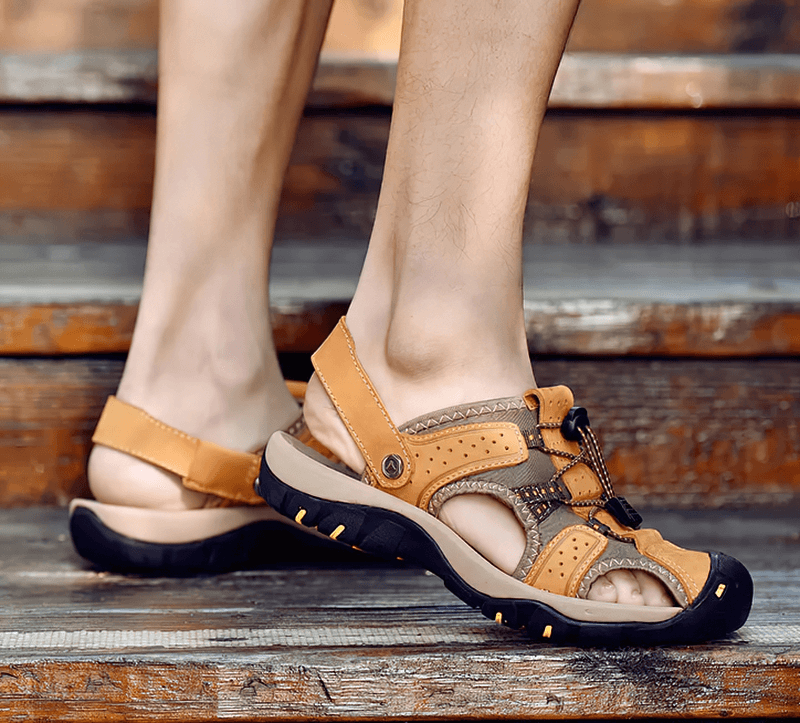 Person wearing Genuine Leather Men's Soft Sandals SF1378 with removable buckle, standing on wooden steps.