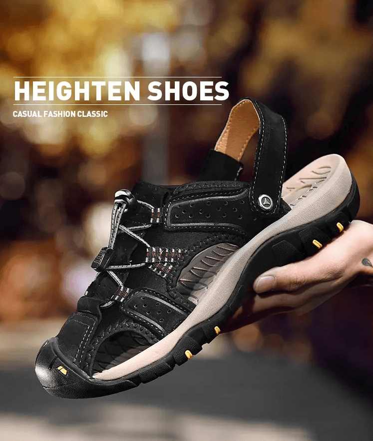 Stylish men's black leather sandals with rubber soles and removable buckle, being held to showcase design.