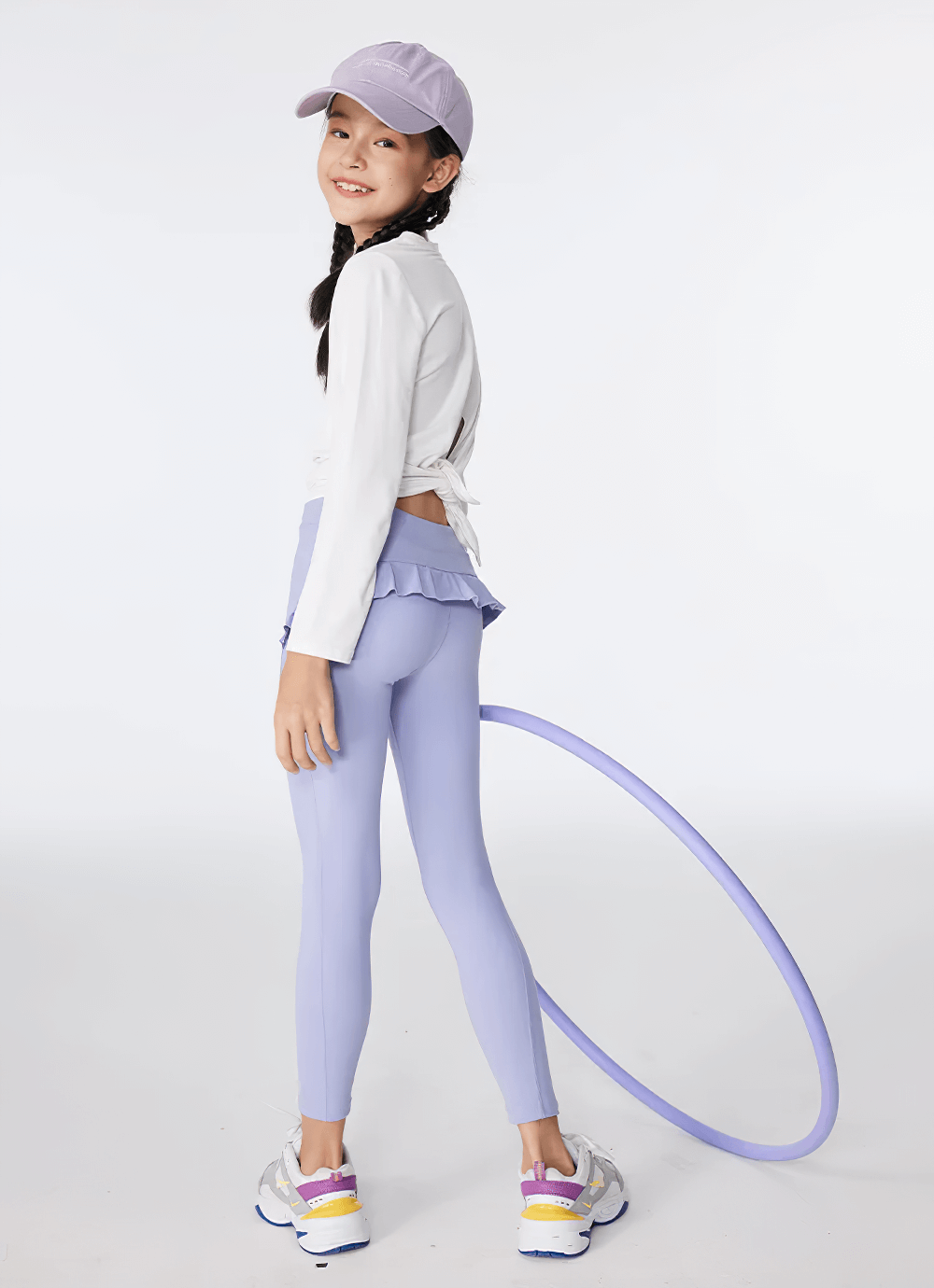Girl wearing Girls Athletic Leggings with Ruffled Waistband - SF3622 in blue, posing with a hula hoop, showcasing flexibility and style.