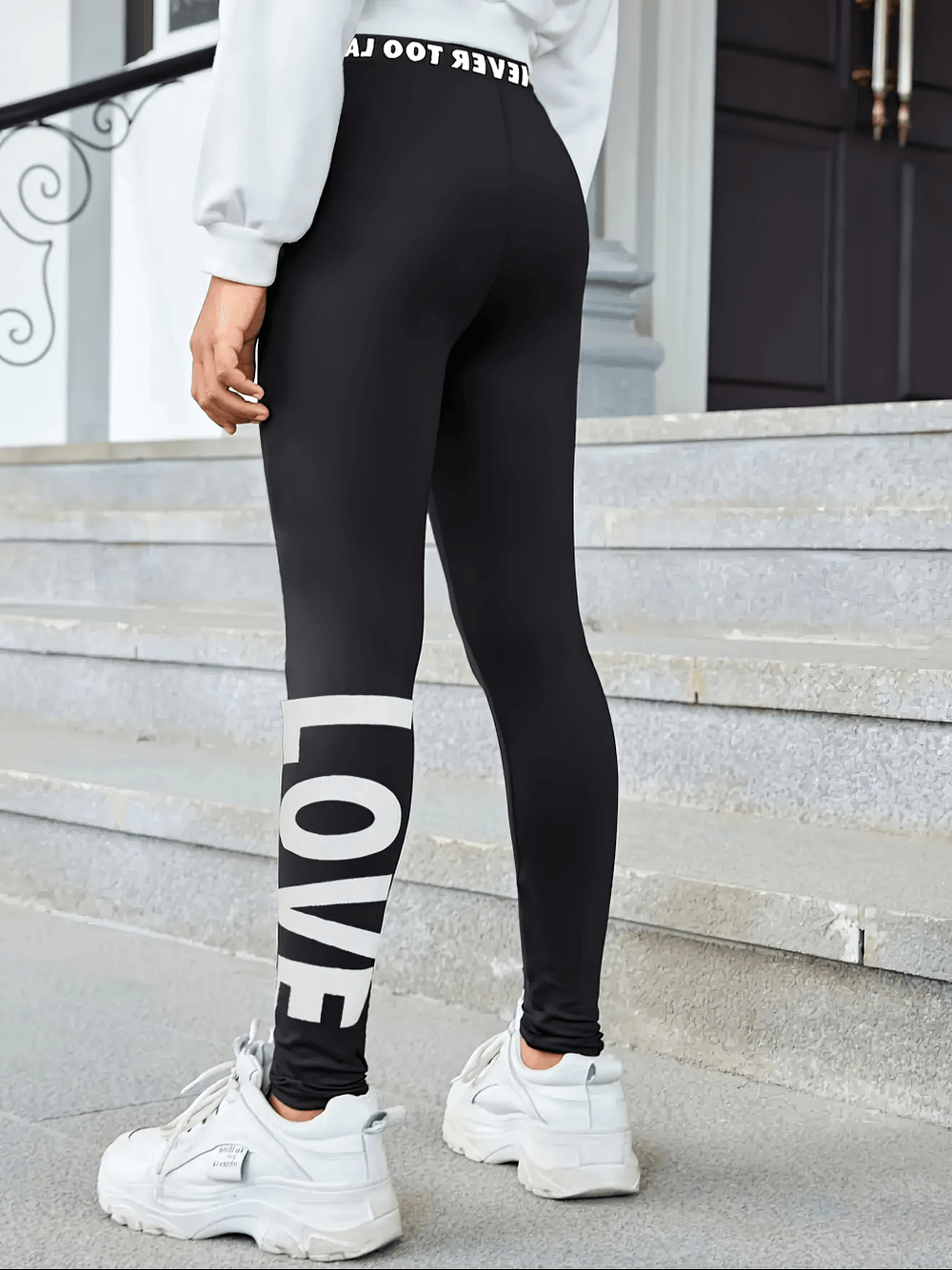 Girl wearing Girls Black Leggings and Stretch Waistband - SF3677 with LOVE print, showing high-stretch fitness design for yoga or training.