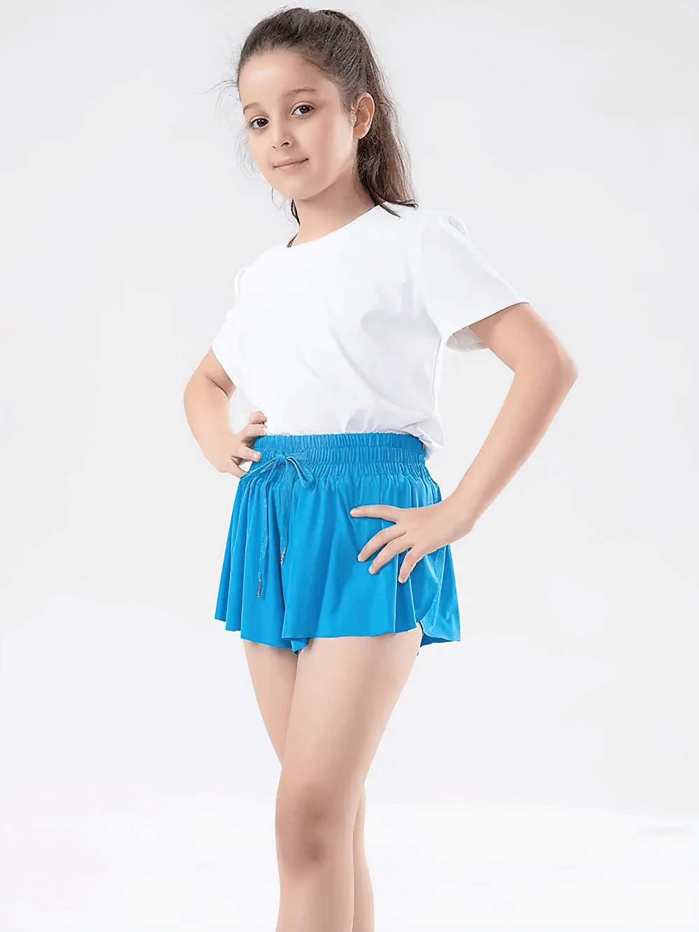 Girl wearing Girls' Bright Sports Shorts with Pleated Design - SF3829 in vibrant blue with elastic waist and side pocket