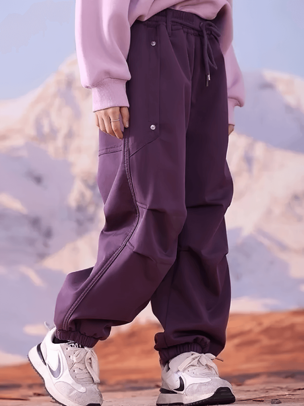 Girl wearing purple Girls Cargo Pants with Fleece Lining and Pockets - SF3704, standing outdoors in front of a snowy mountain.