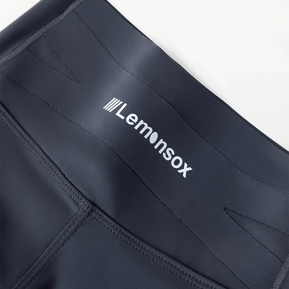 Close-up of Lemonsox logo on Girls Elastic Stretch Ankle Leggings for Fitness - SF3756 in smooth black fabric.
