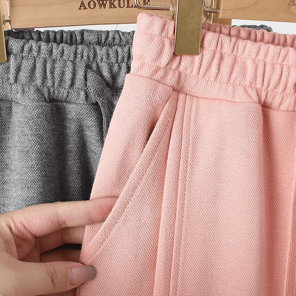 Close-up of Girls High-Waist Cotton Jogger Pants with Pockets - SF3658 in pink and grey hanging on a rack.
