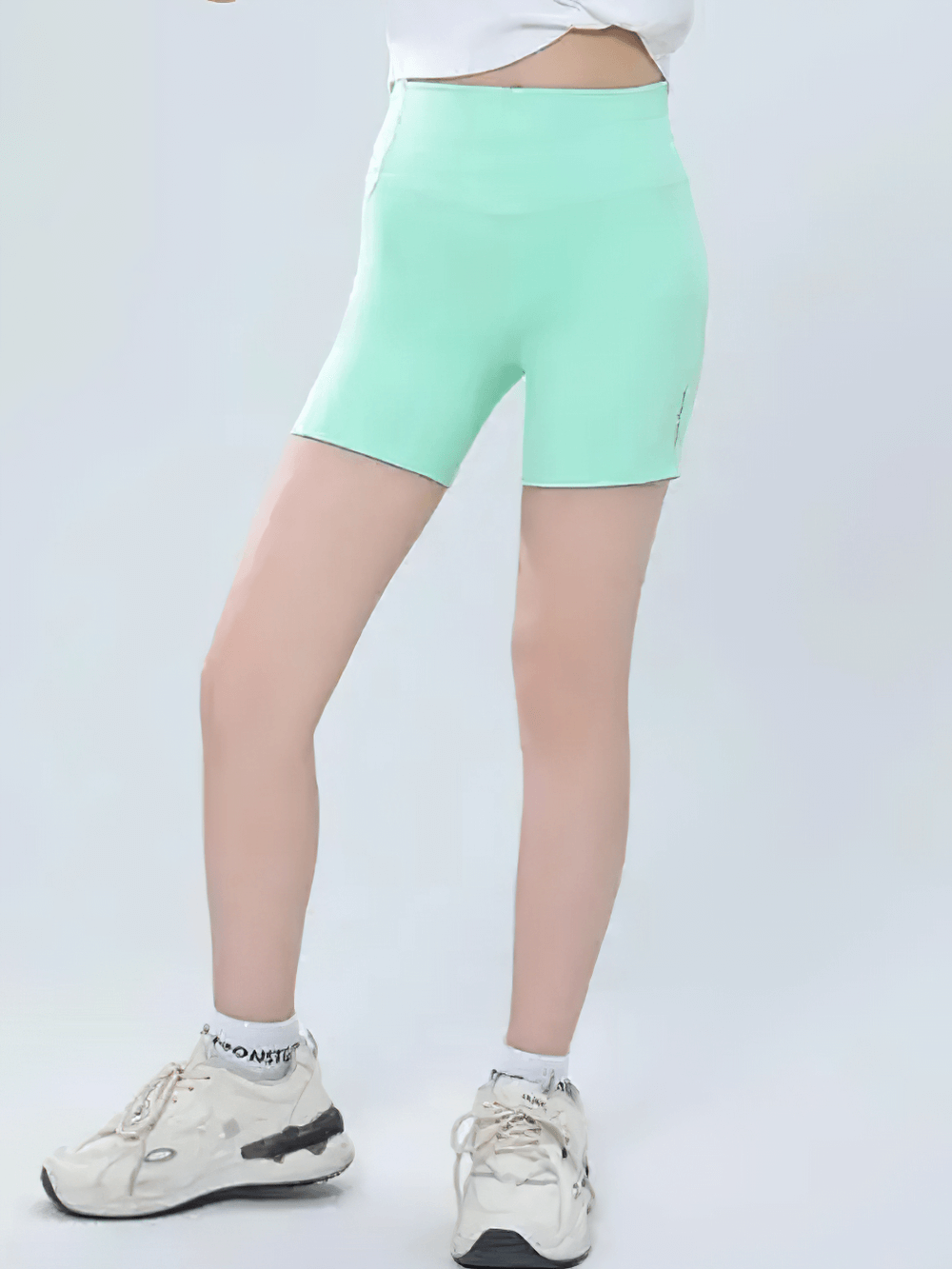Model wearing Girls High-Waisted Sport Shorts for Yoga and Running - SF3838 in mint green, demonstrating flexible athletic wear.