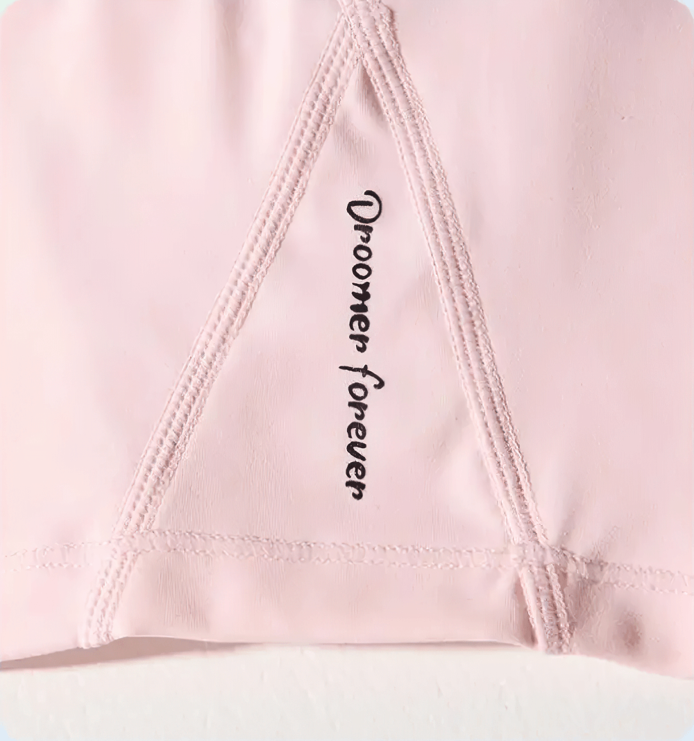 Close-up of pink athletic garment fabric with 'Droomer forever' text in black.