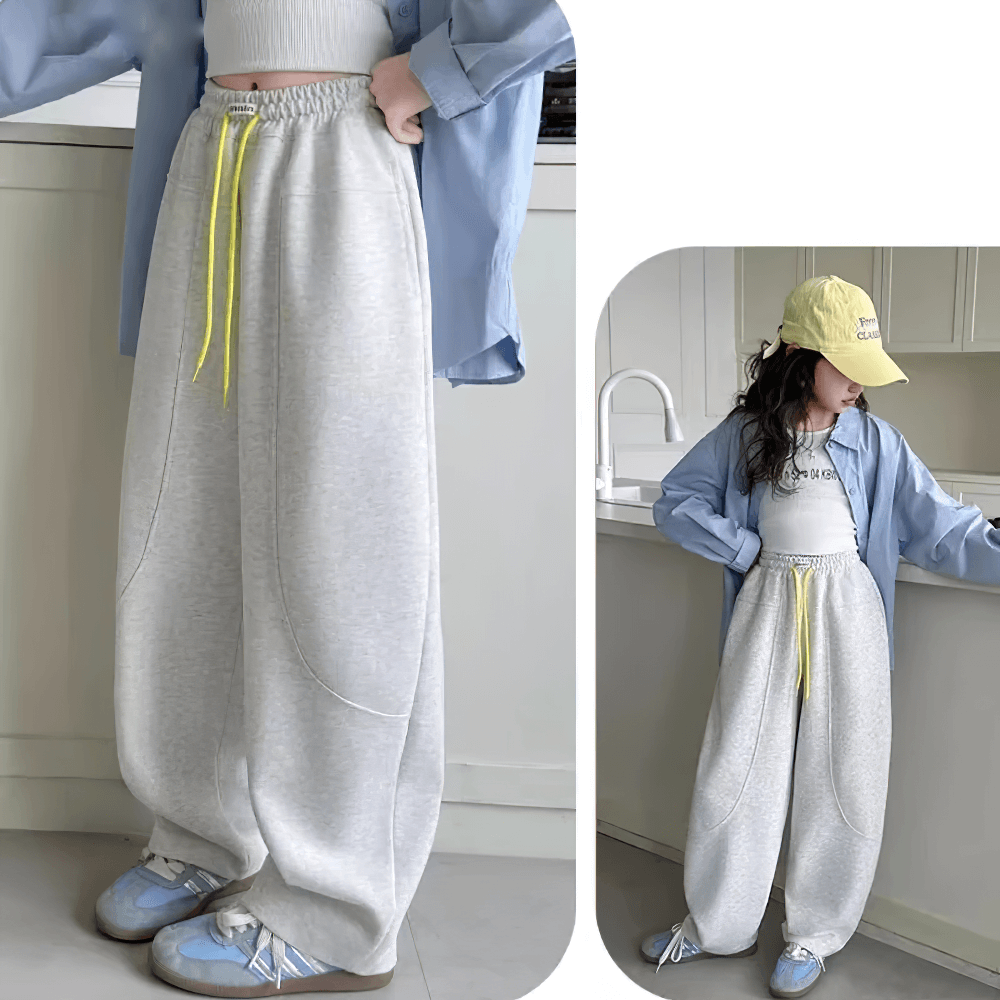 Girls wearing the Girls Loose Fit Sporty Pants with Drawstring Waist - SF3709, windproof design, in a kitchen. Style and comfort in action.