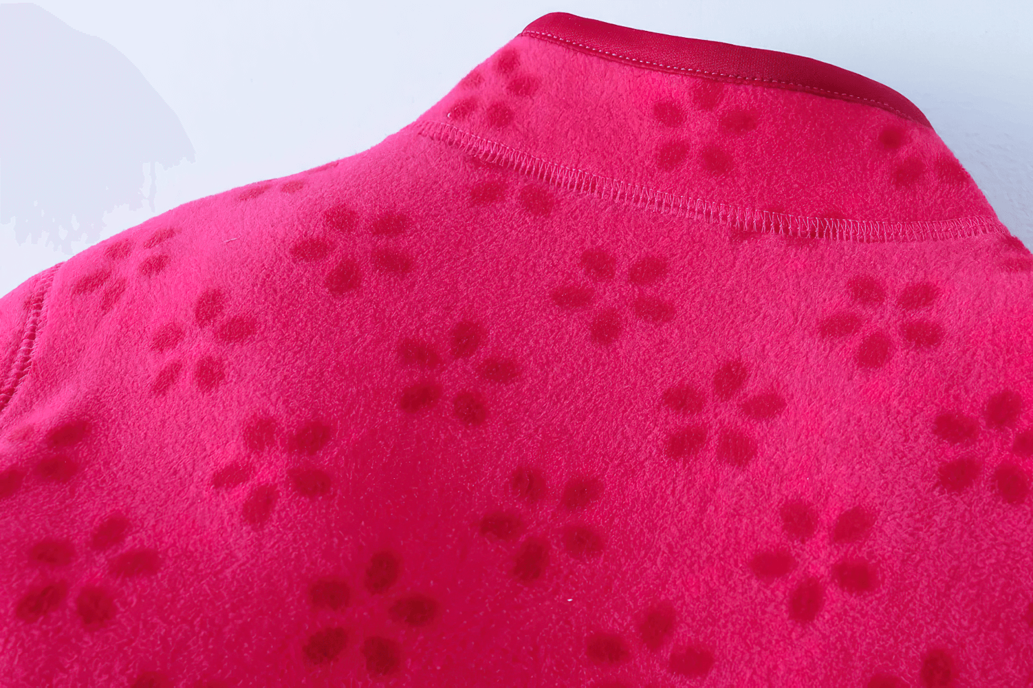 Close-up of Girls Rose Red Fleece Zip Jacket with Pockets - SF3530, showing floral pattern and neat stitching on soft fleece material.