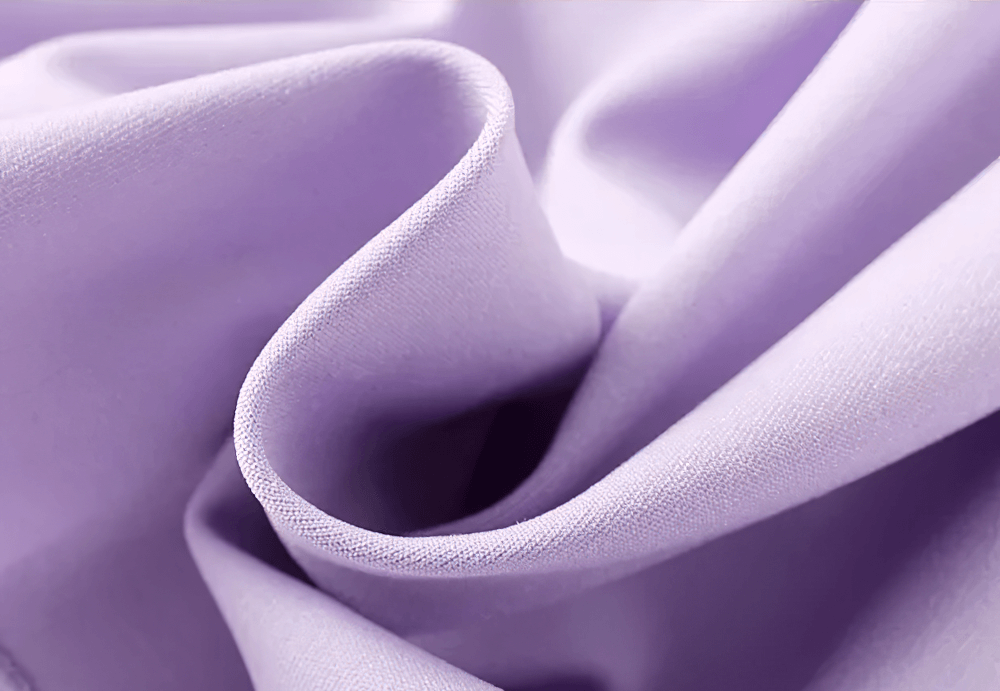 Close-up of smooth lilac fabric, showcasing its soft texture and elegant drape.