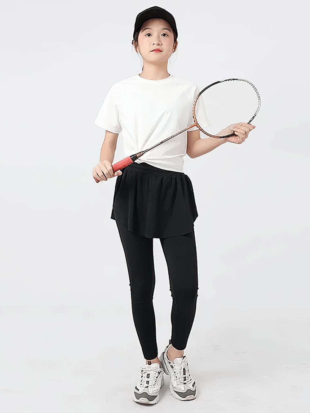 Girl wearing Girls Sports Leggings with Flow Skirt Design - SF3673, holding badminton racket, showcasing sporty and playful style.