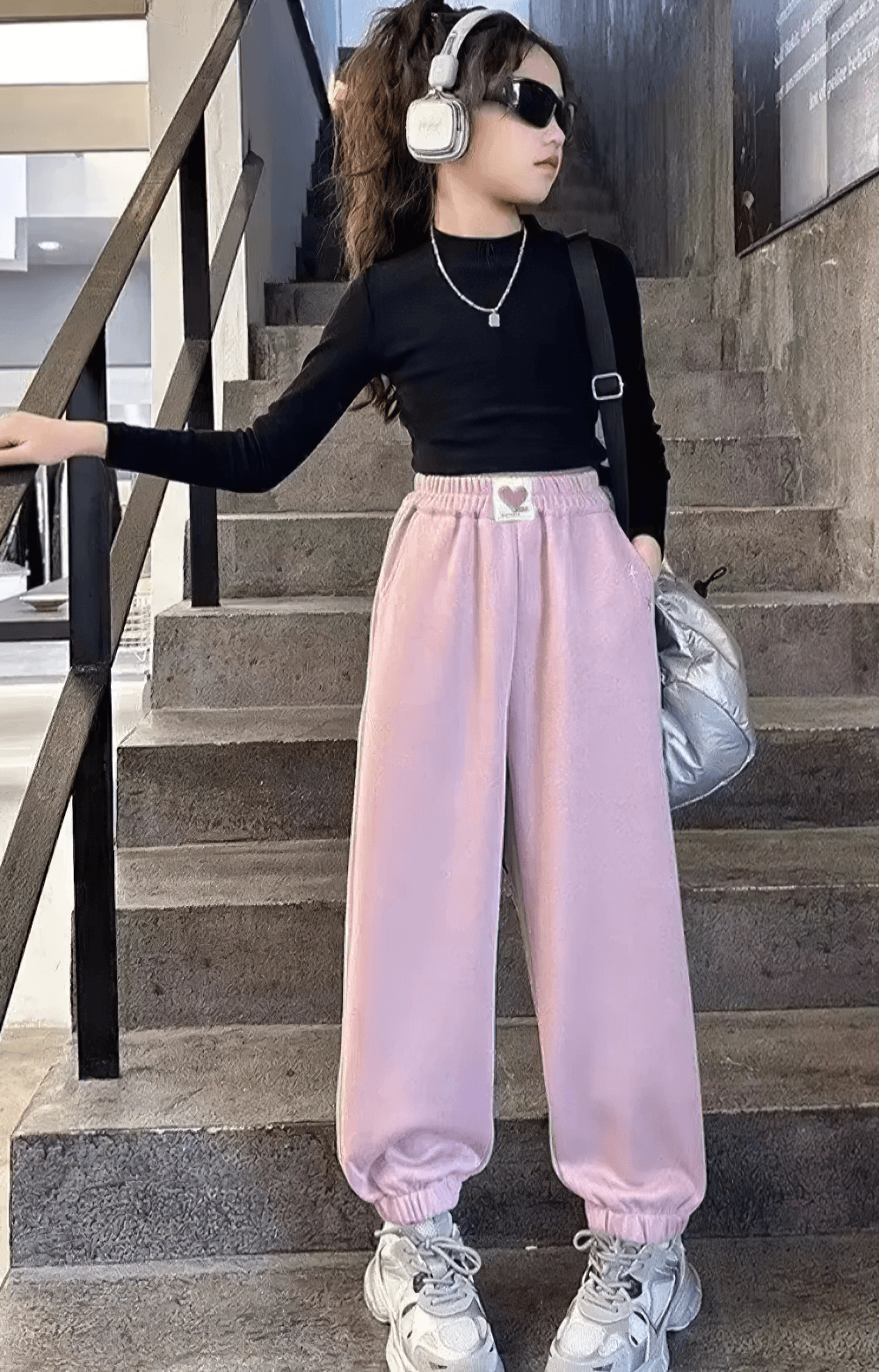 Girl wearing Girls Star Print Loose Sports Pants with Elastic Waist - SF3728, headphones, and sunglasses on stairs.