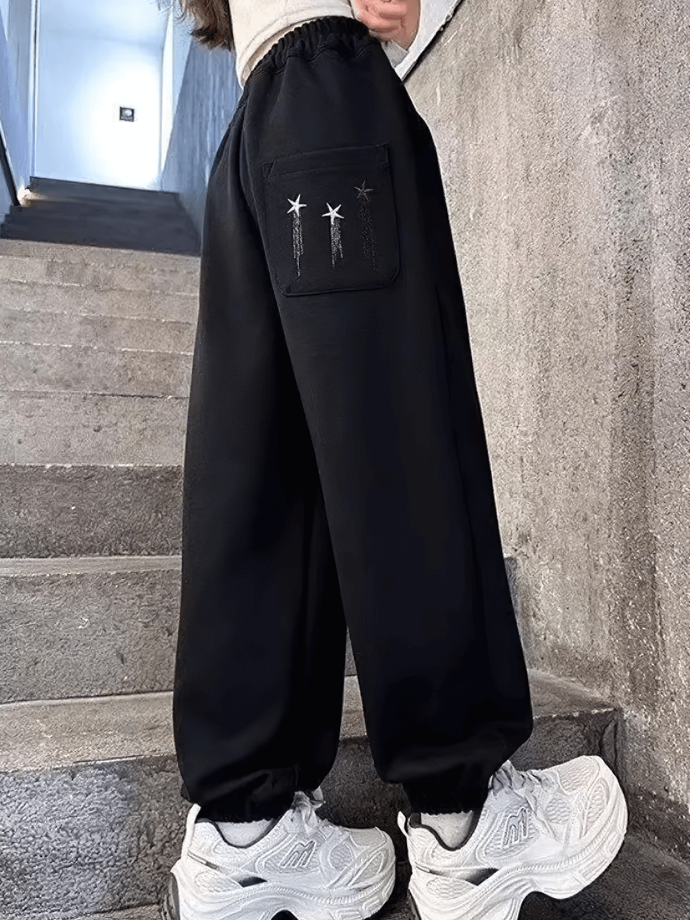 Girl wearing Girls Star Print Loose Sports Pants with Elastic Waist - SF3728, showcasing trendy star design and elastic ankles.