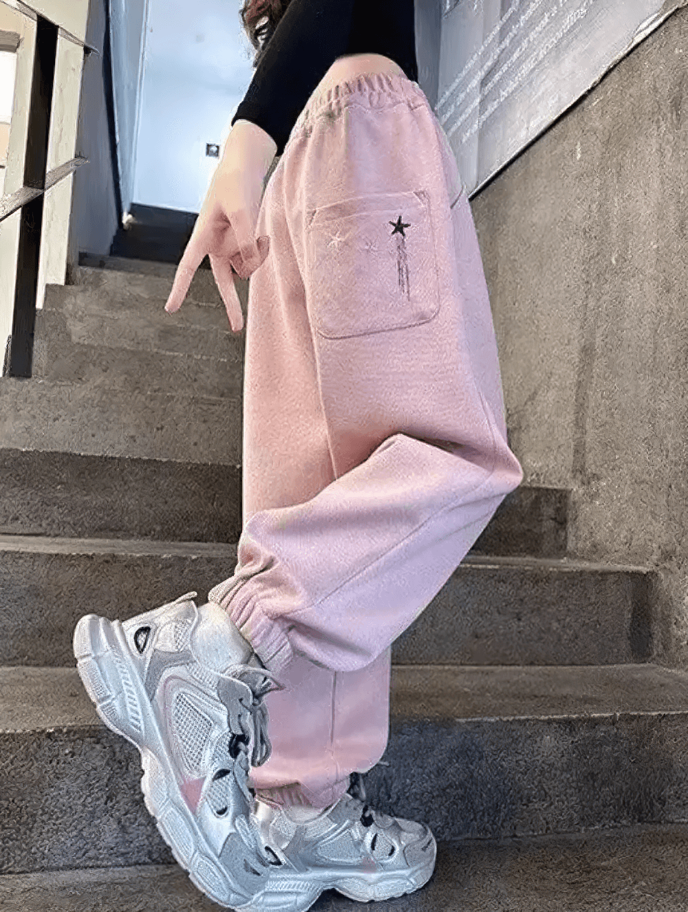 Girl wearing Girls Star Print Loose Sports Pants with Elastic Waist - SF3728, showing elastic ankles and star-themed design, side view.