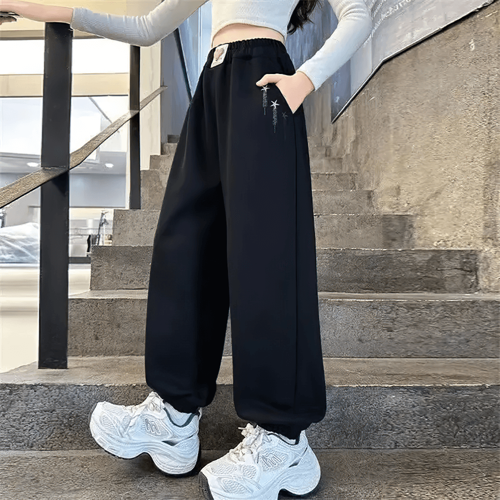 Model wearing Girls Star Print Loose Sports Pants with Elastic Waist - SF3728, showcasing casual style and star-themed prints.