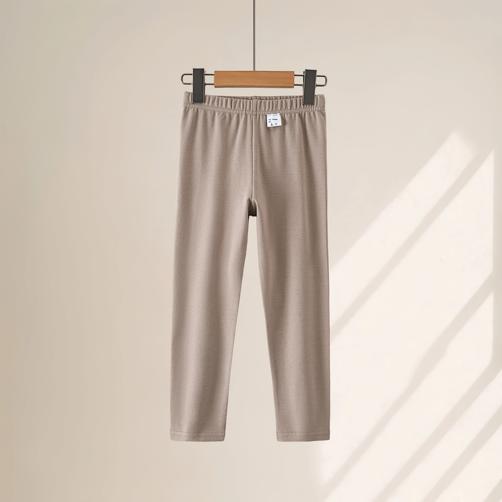 Girls Stretchy Sport Leggings in Soft Solid Colors - SF3681, lightweight and sleek kids leggings in beige shade, hanging on a wooden hanger.