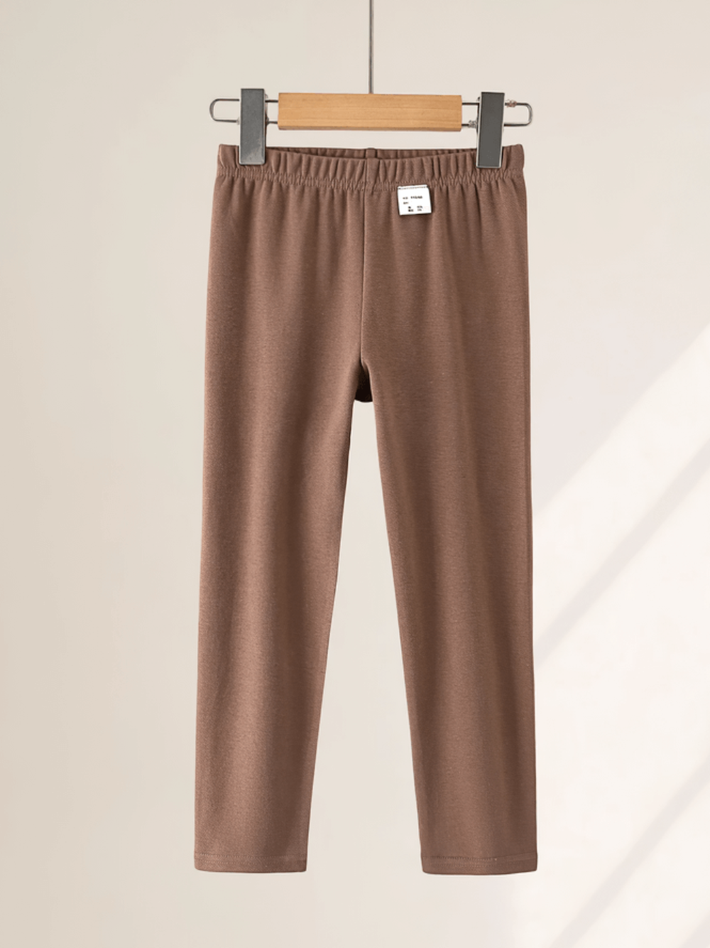 Girls Stretchy Sport Leggings in Soft Solid Colors - SF3681 hanging on a rack, showcasing sleek fit and soft fabric.