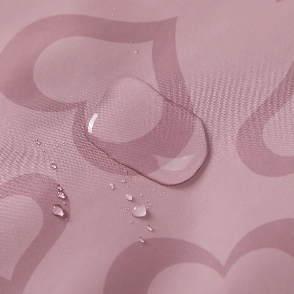 Close-up of the waterproof material with heart print on the Girls Waterproof Heart Print Hooded Jacket - SF3569.