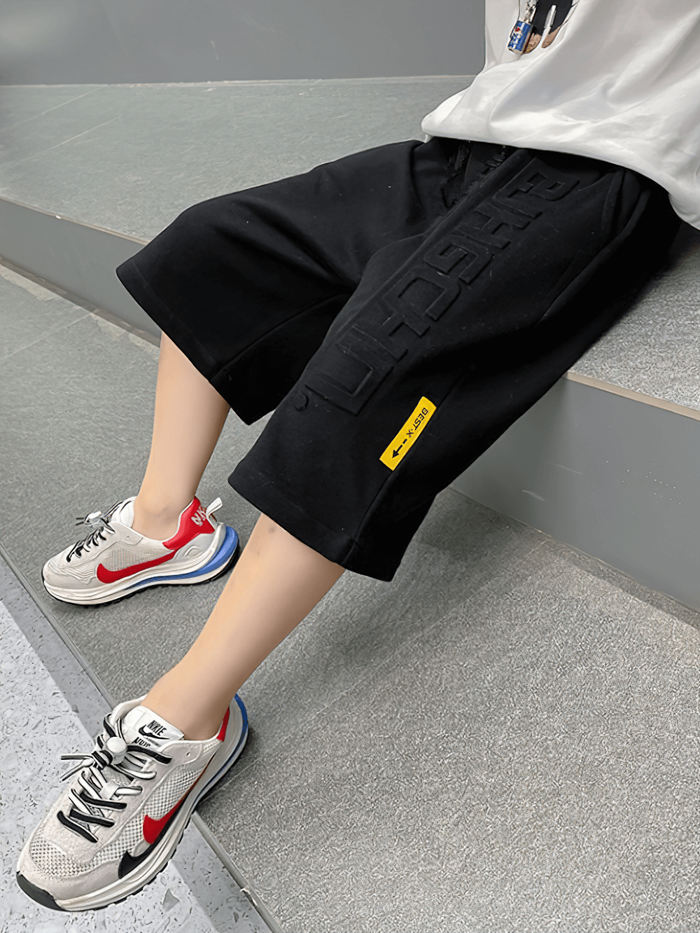 Stylish black Graphic Drawstring Knee-Length Sports Shorts - SF3771 for kids with graphic print and drawstring on a sitting child