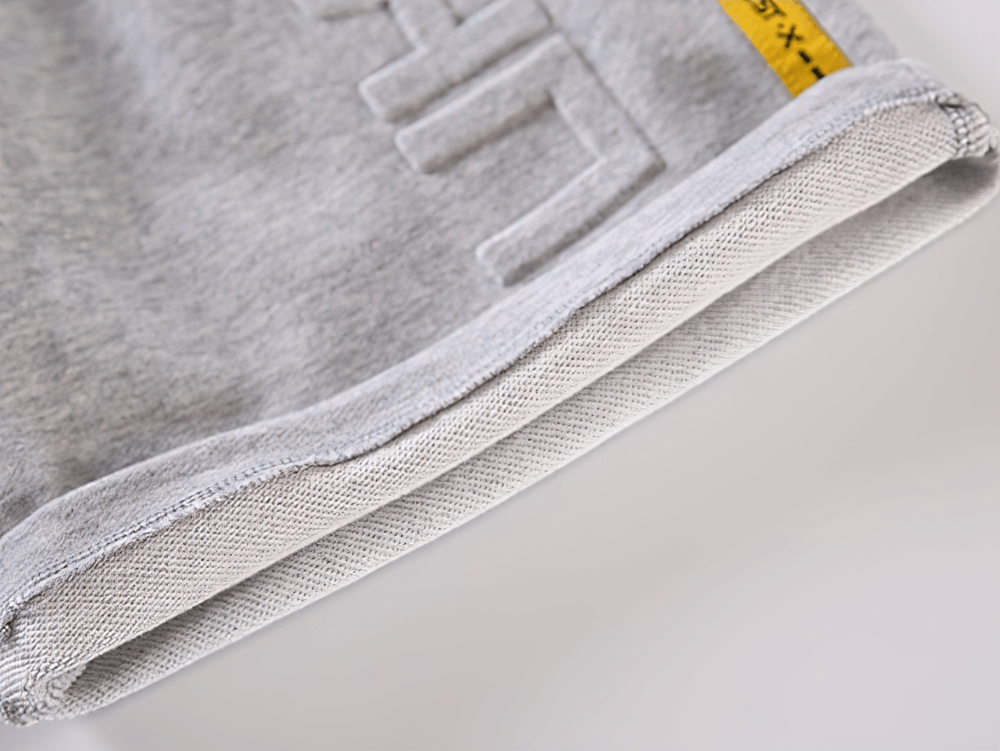 Close-up view of grey fabric on Graphic Drawstring Knee-Length Sports Shorts - SF3771 highlighting texture and design details.
