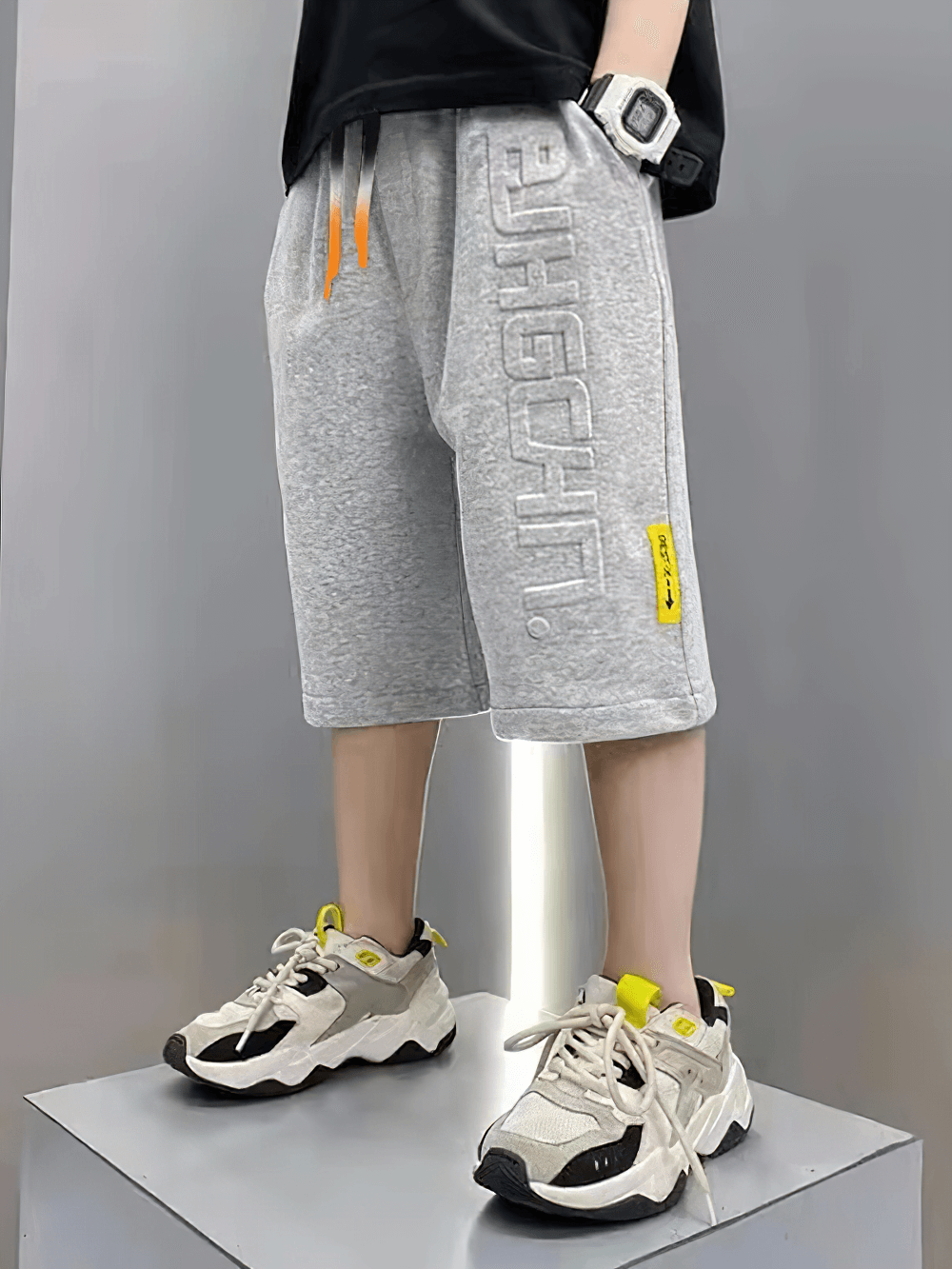 Child modeling Graphic Drawstring Knee-Length Sports Shorts - SF3771 in gray with trendy sneakers, highlighting relaxed fit and style.