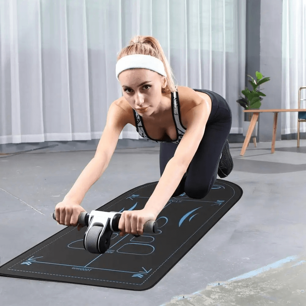 Woman using guided ab roller exercise mat with marked zones indoors.