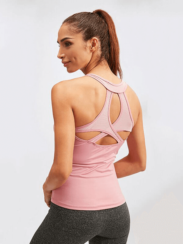 Woman in a pink asymmetric back tank top for yoga, showcasing breathable, anti-shrink fabric. Ideal for dance and fitness.