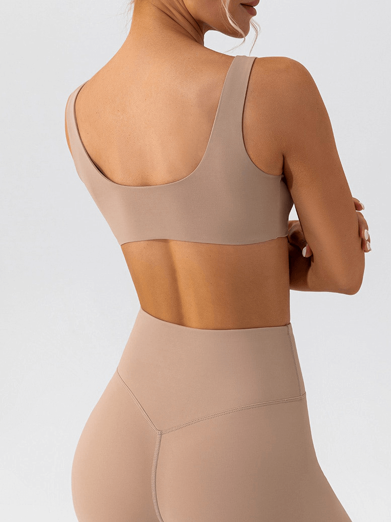 Back view of seamless sports bra and leggings set for yoga, featuring breathable and anti-bacterial fabric in neutral color.